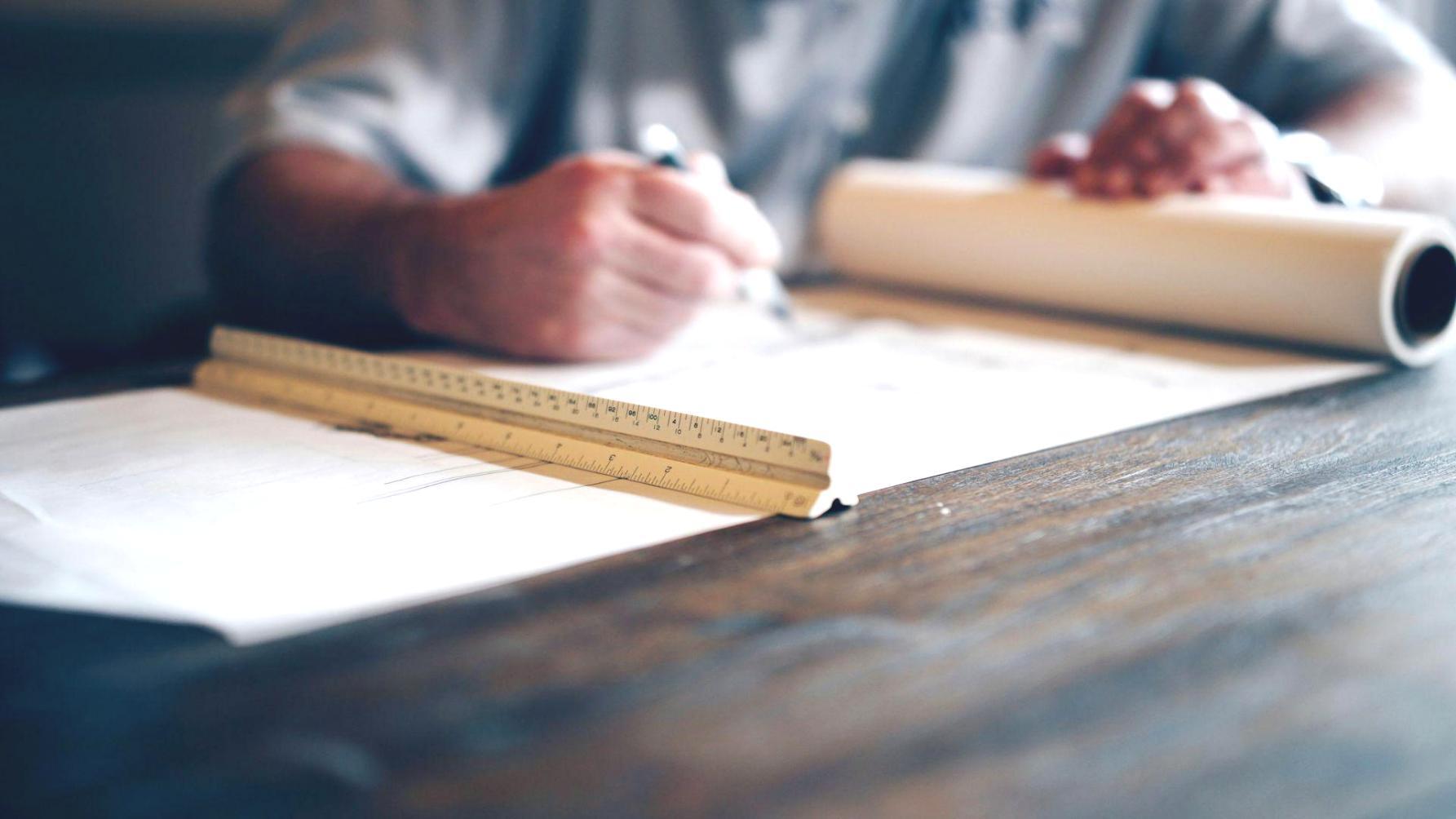 Person reviewing financial charts and planning documents on desk
